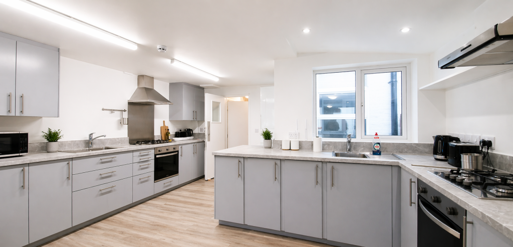Modern kitchen extension in Islington at Kingsdown Road N19 with fitted grey units, island storage and communal HMO layout